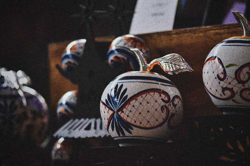 Esferas decorativas de Talavera con forma de granada y motivos florales en azul y rojo