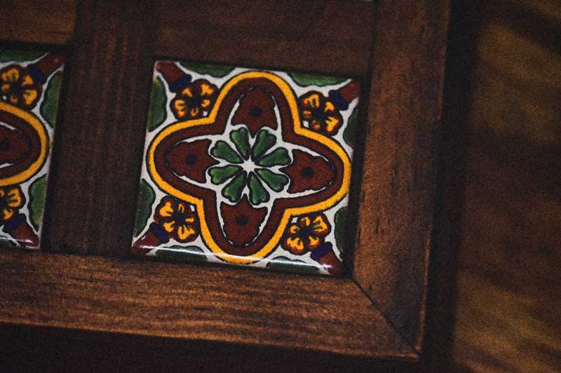 Azulejo de Talavera con diseño floral tradicional enmarcado en madera oscura